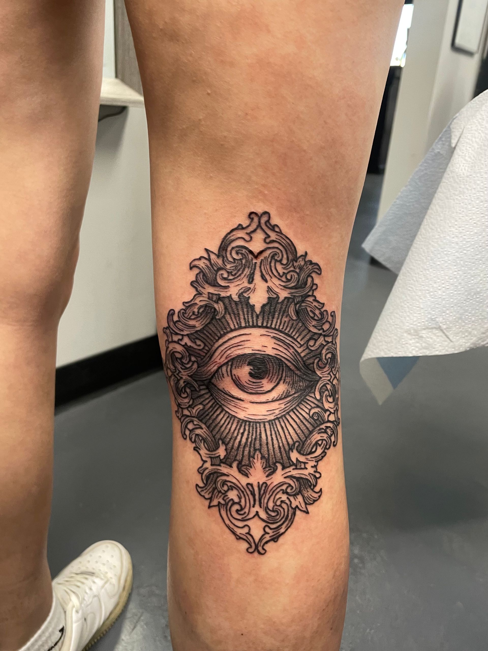 A person has a tattoo of an eye on their knee.