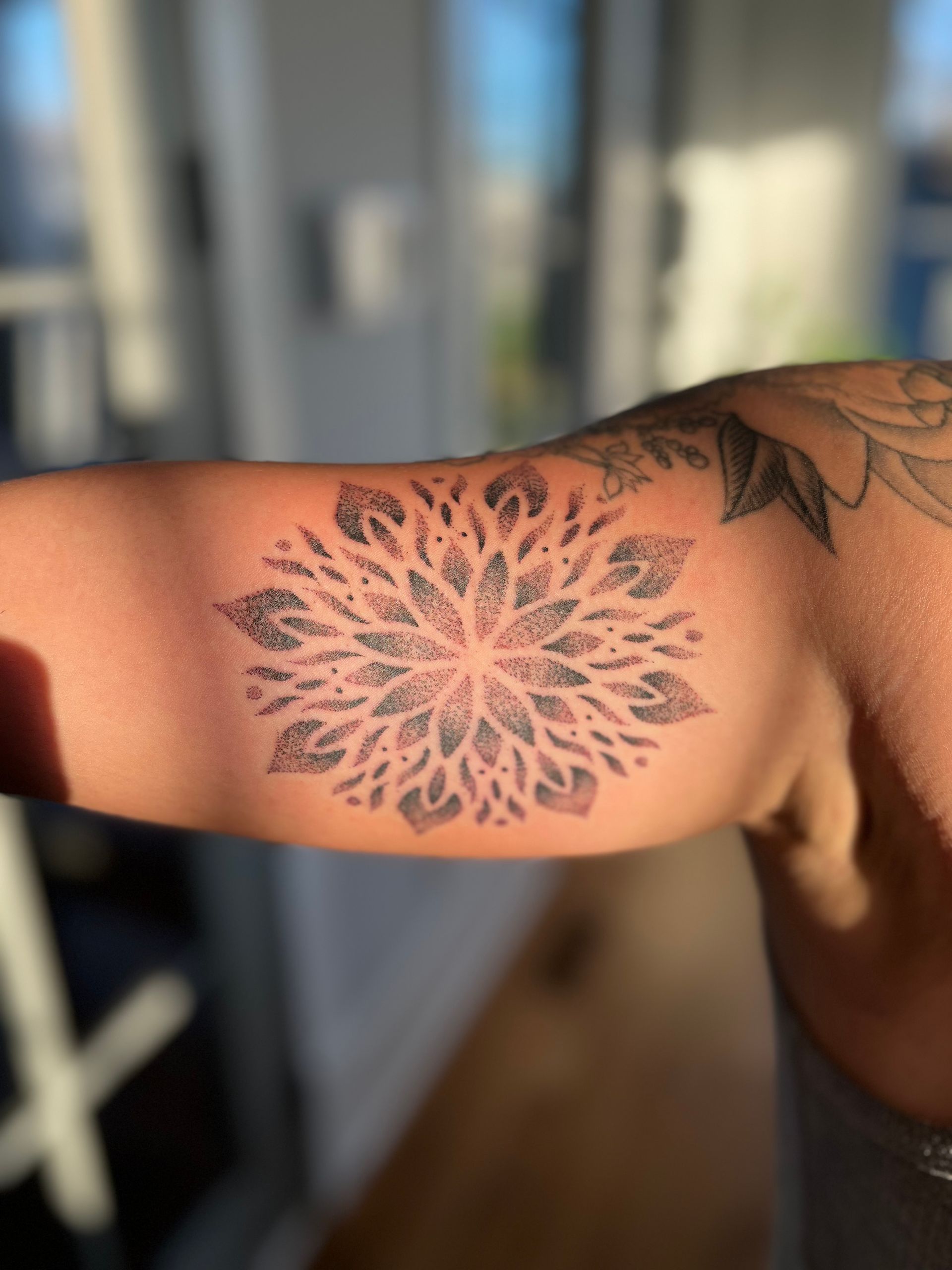 Mandala-inspired floral tattoo on the arm, showcasing fine dot work. Tattoo done at a custom tattoo shop in Raleigh.