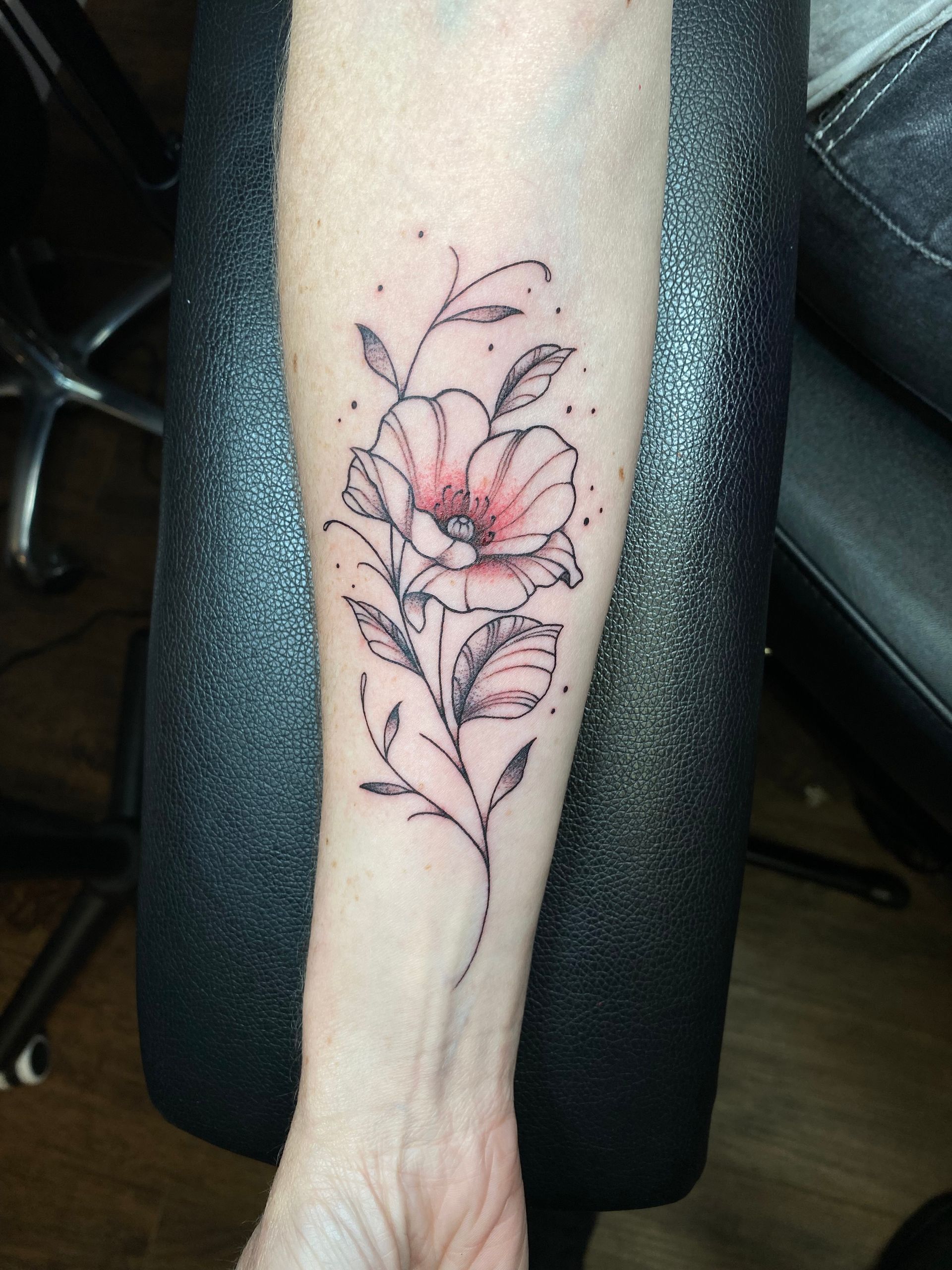 Floral tattoo with red accents by a skilled Raleigh tattoo artist. Walk-in tattoo shops in Raleigh available custom tattoos.