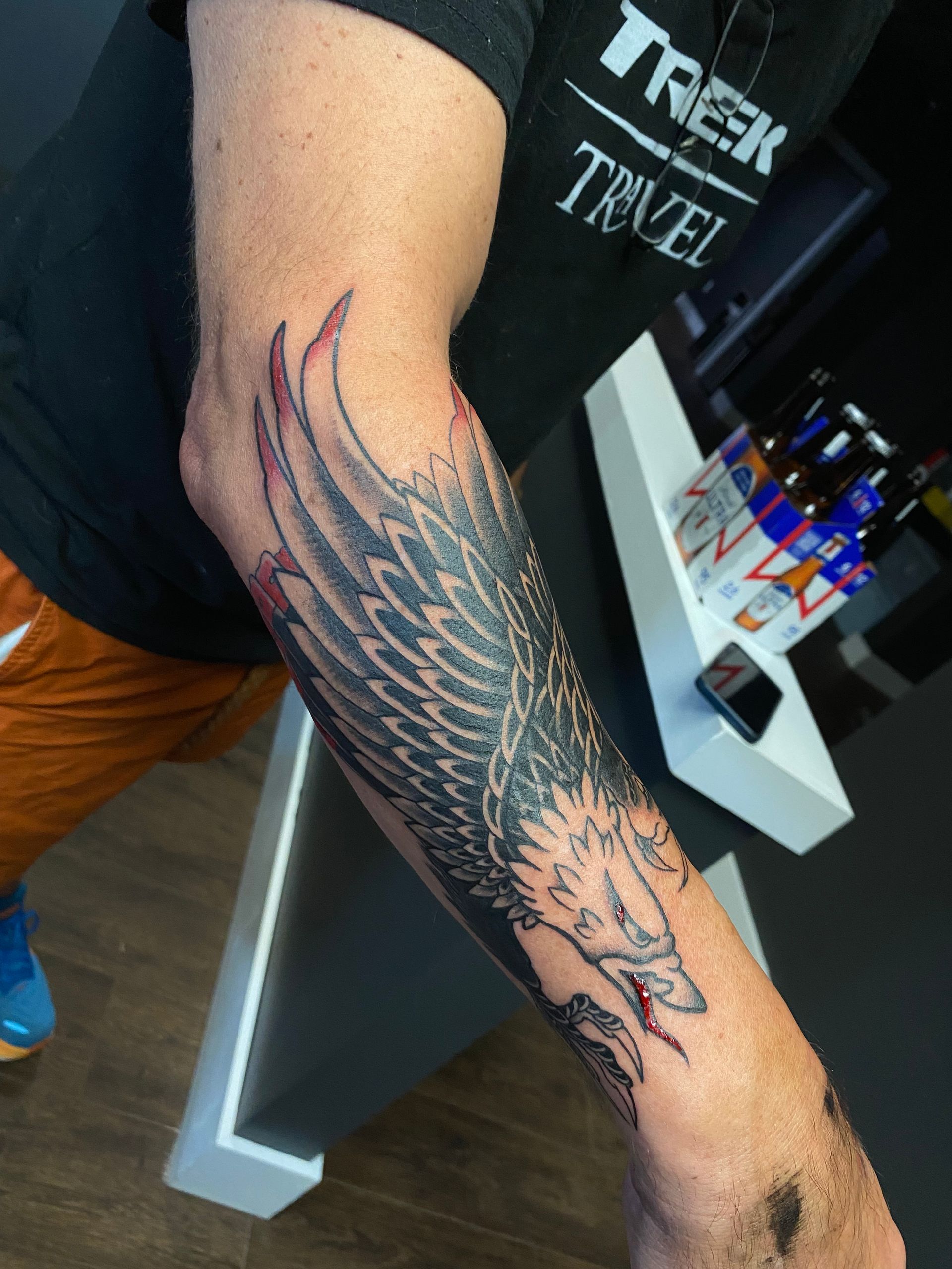 Arm tattoo of a large wing design in progress at a tattoo shop in downtown Raleigh NC.