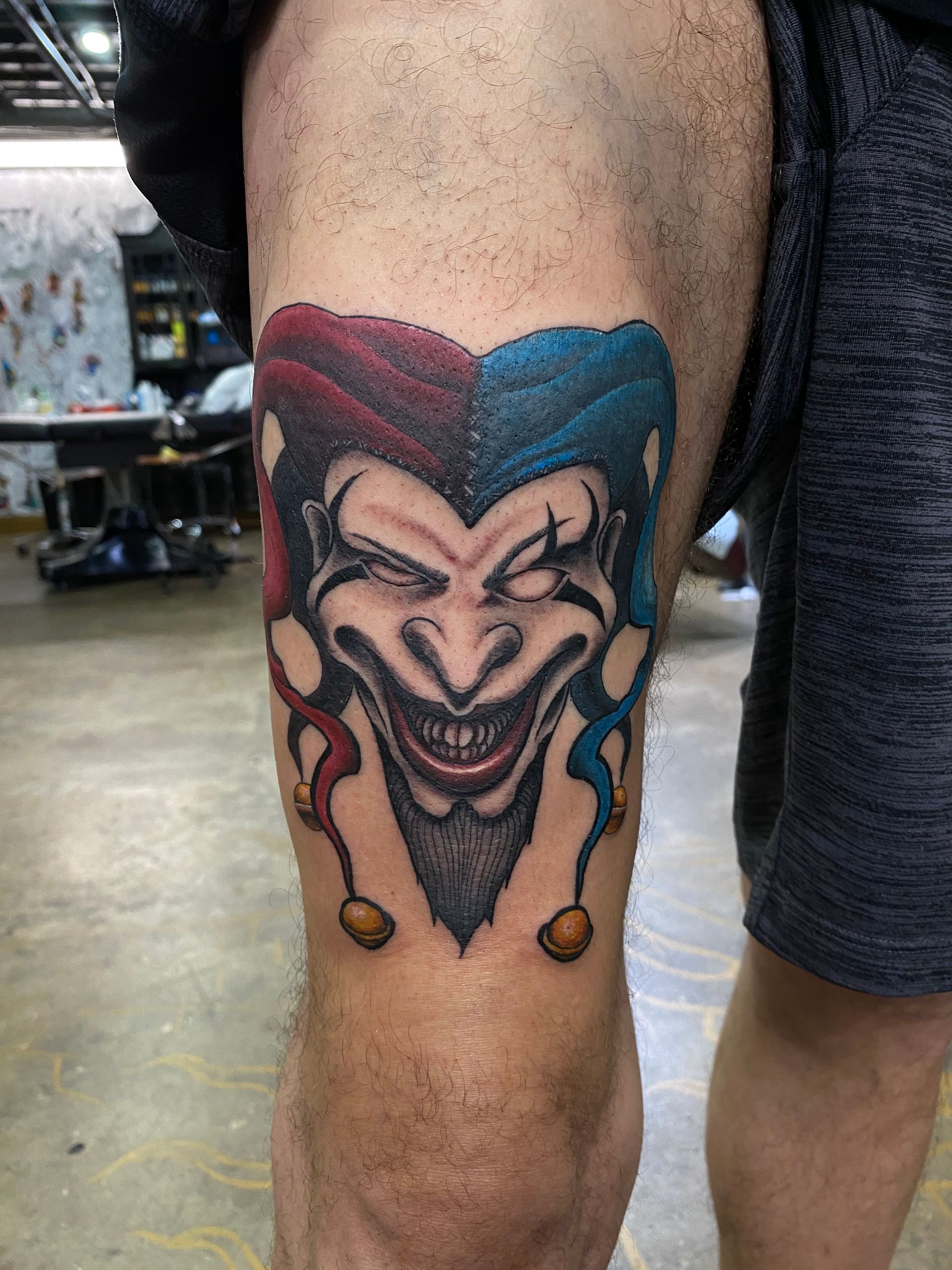 Colorful jester tattoo on the leg, designed by one of the best tattoo artists in Raleigh NC.