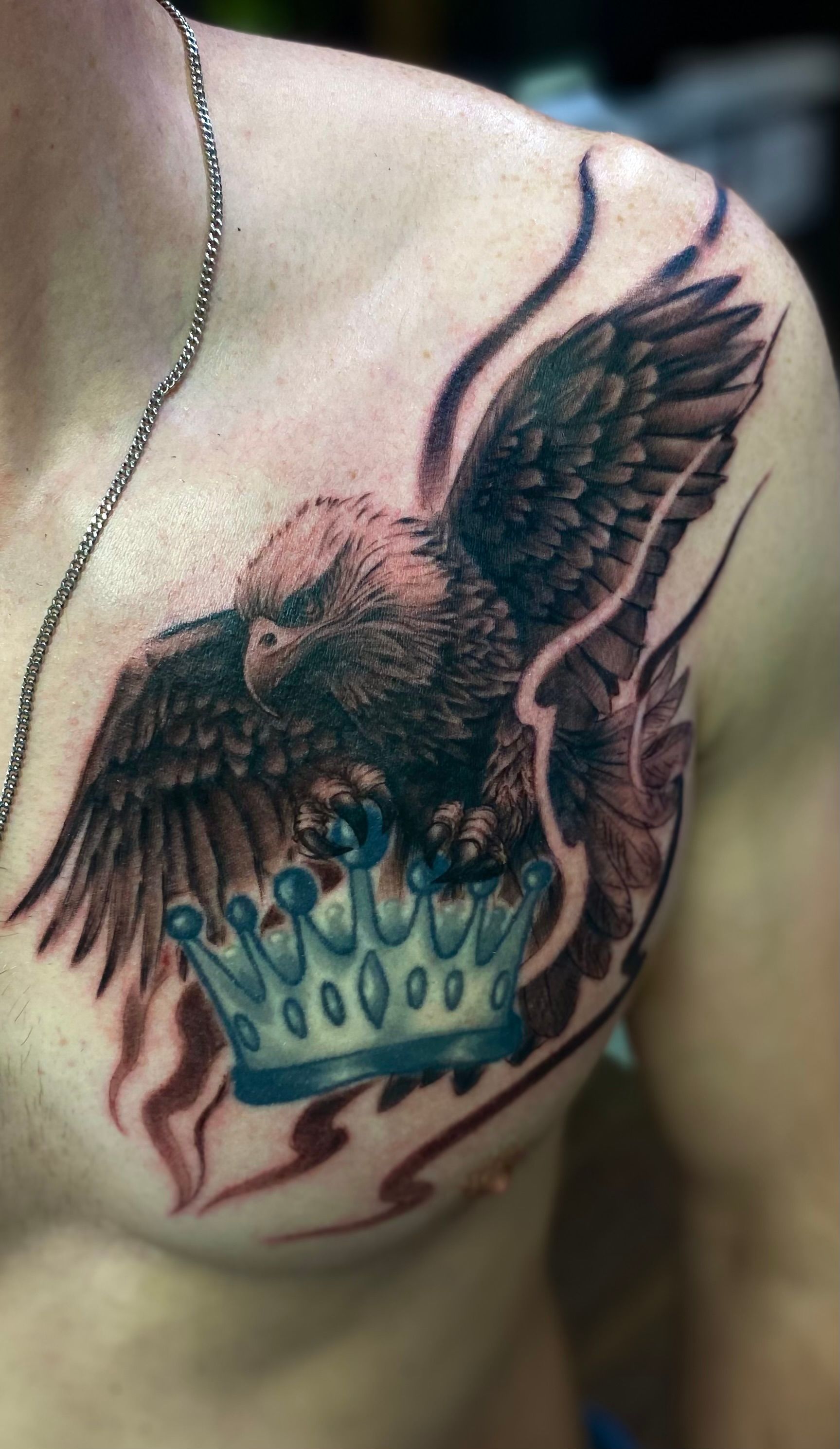 Black and grey eagle chest tattoo with a crown, inked at a tattoo parlor in Raleigh NC.