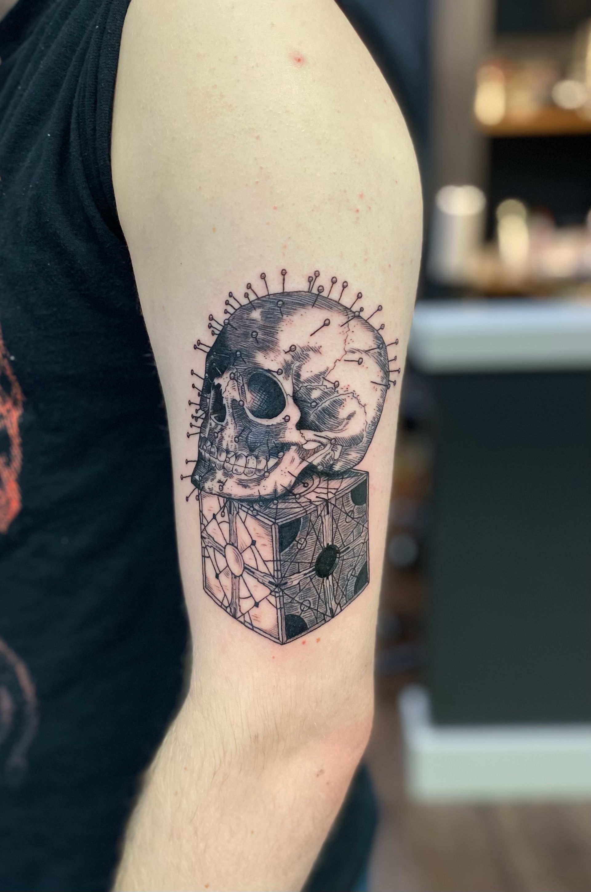 Skull and pins tattoo with a cube on the arm, done at one of the best tattoo parlors in Raleigh NC.