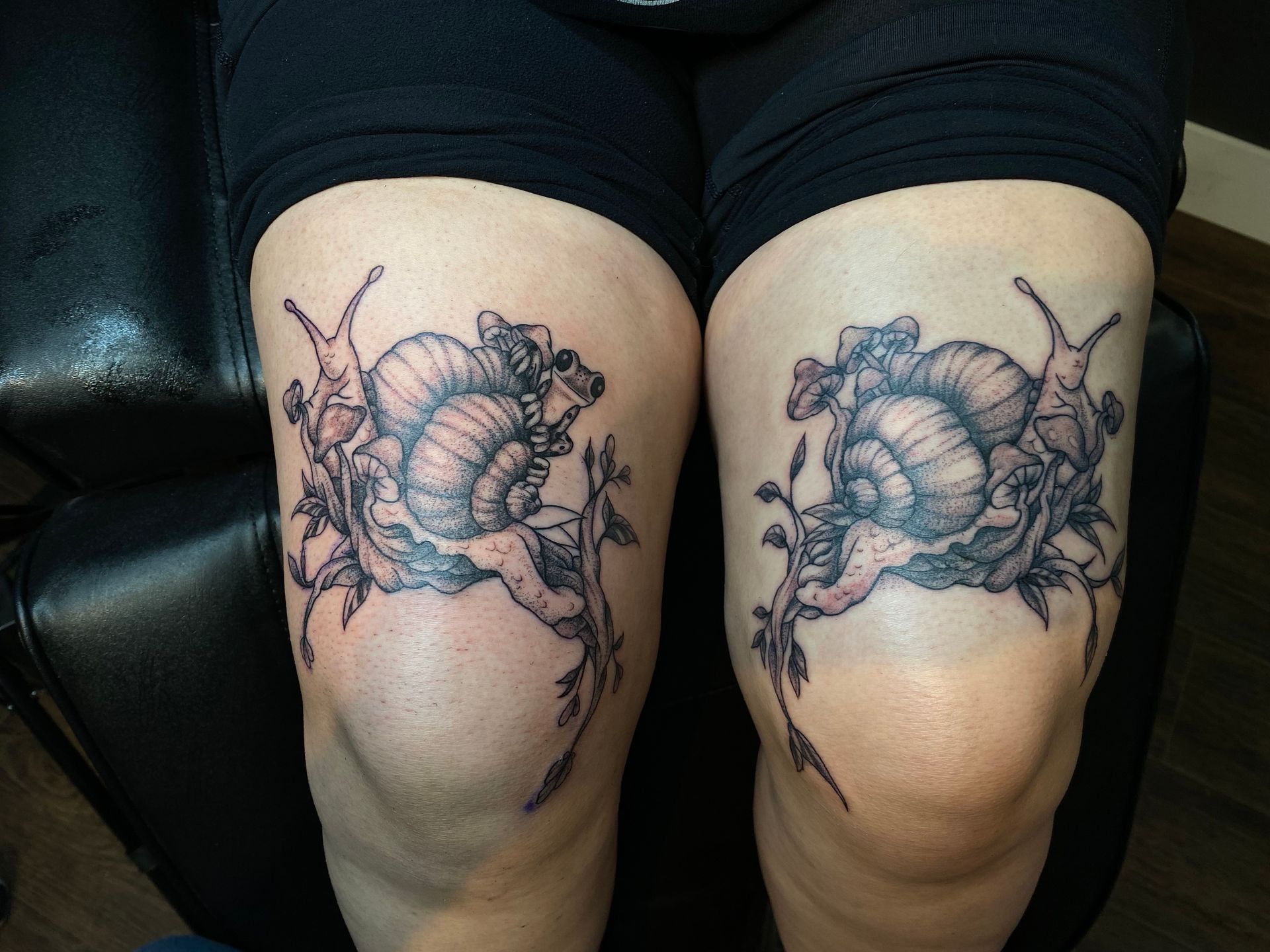 Matching snail tattoos on both thighs, done at one of the best tattoo parlors in North Carolina.