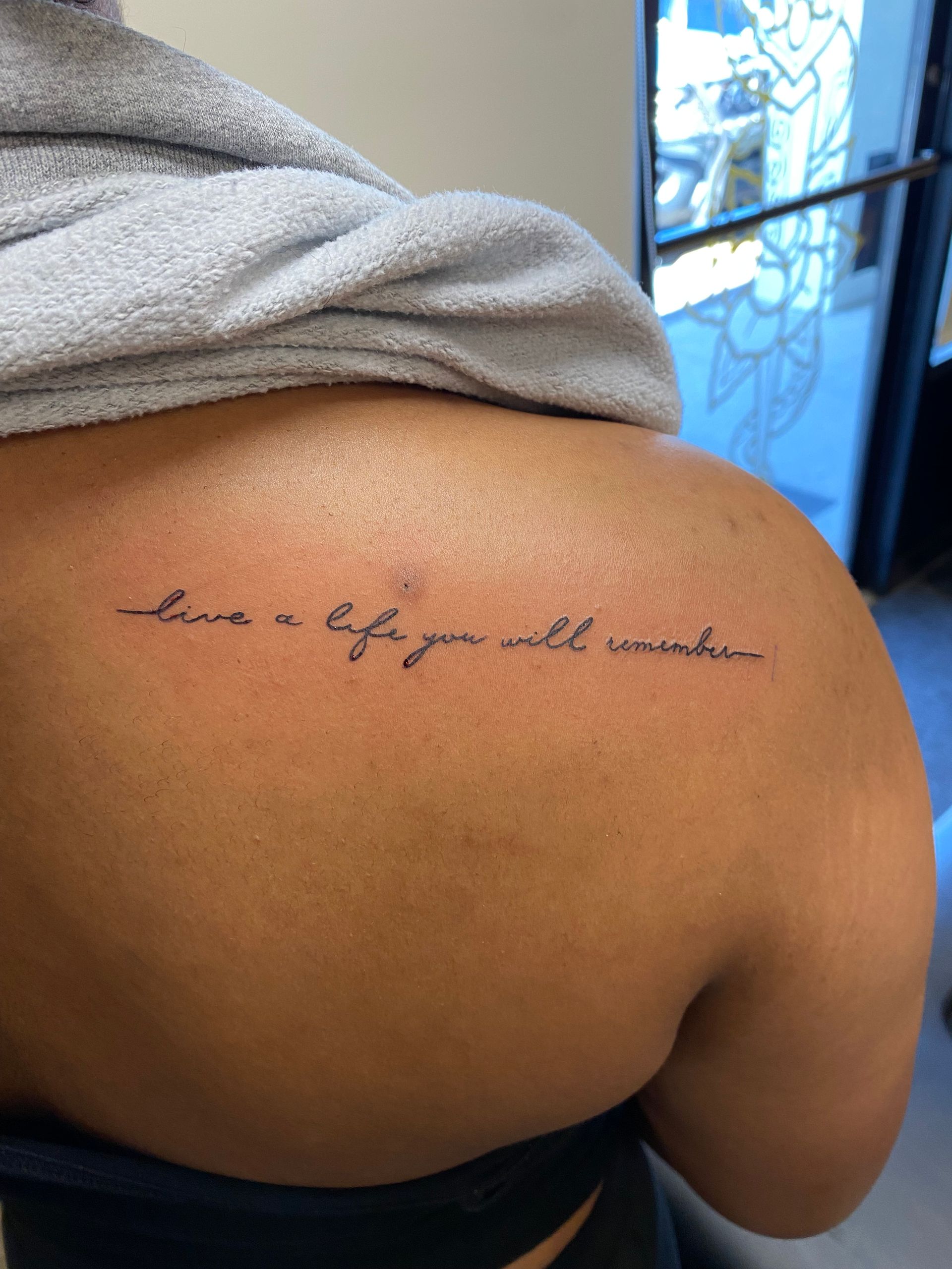 Upper back script tattoo, 'live a life you will remember,' done at Raleigh studio.