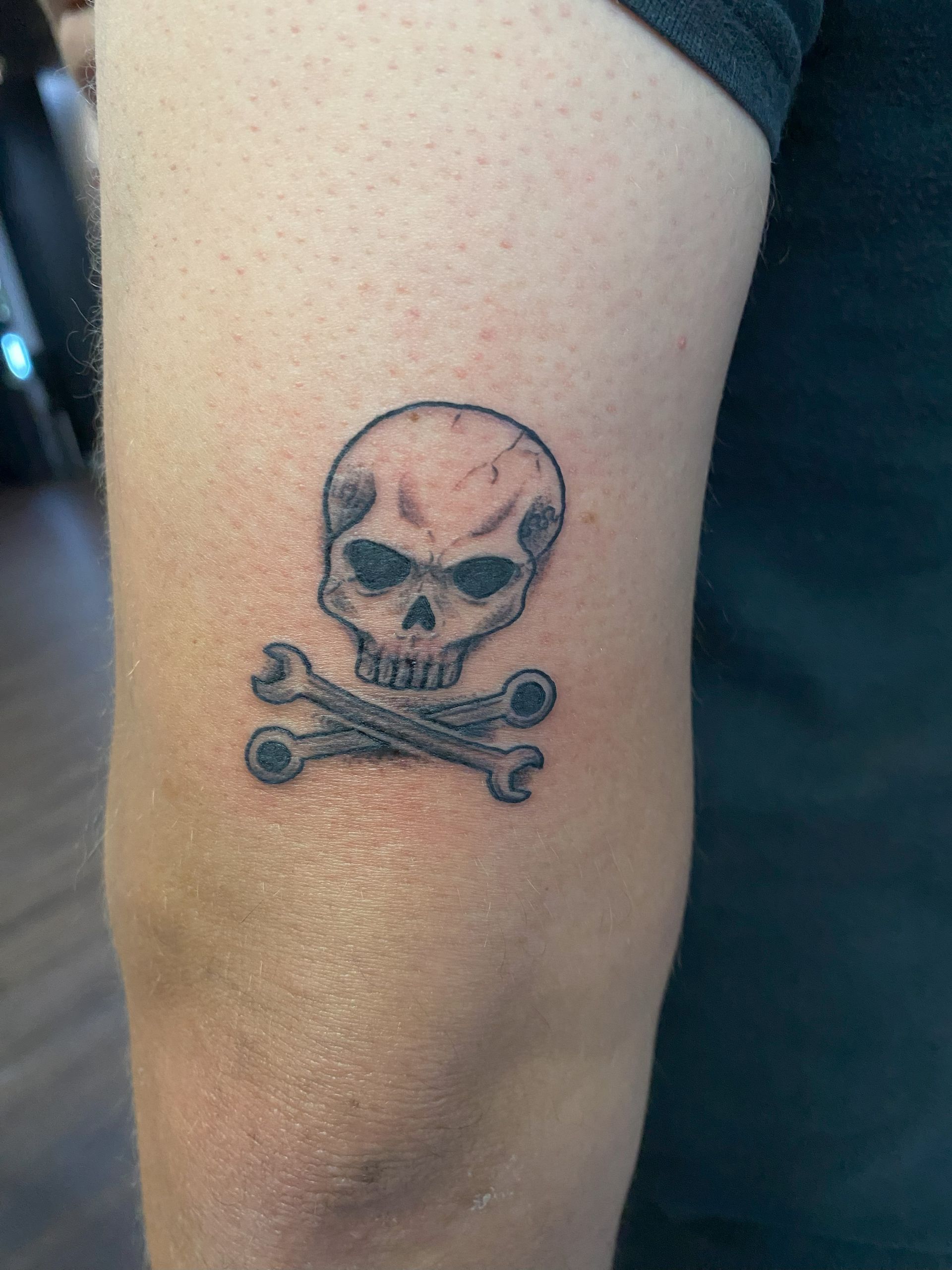 Skull and crossbones black ink tattoo completed at TEETS X Aether flash tattoo event in Raleigh, NC.