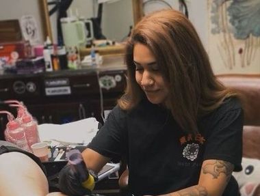 Vanité, Female tattoo artist working on a client, close-up of arm tattoo.