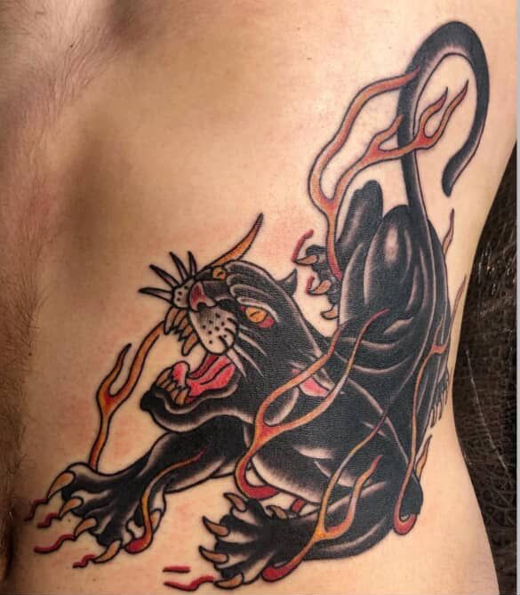 Black panther tattoo with orange flames on side.