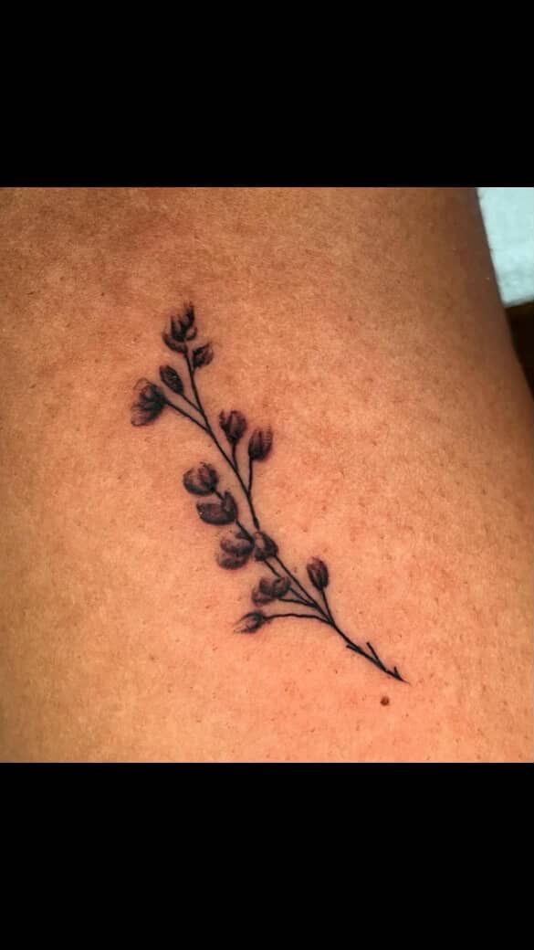 Small black floral tattoo on skin.
