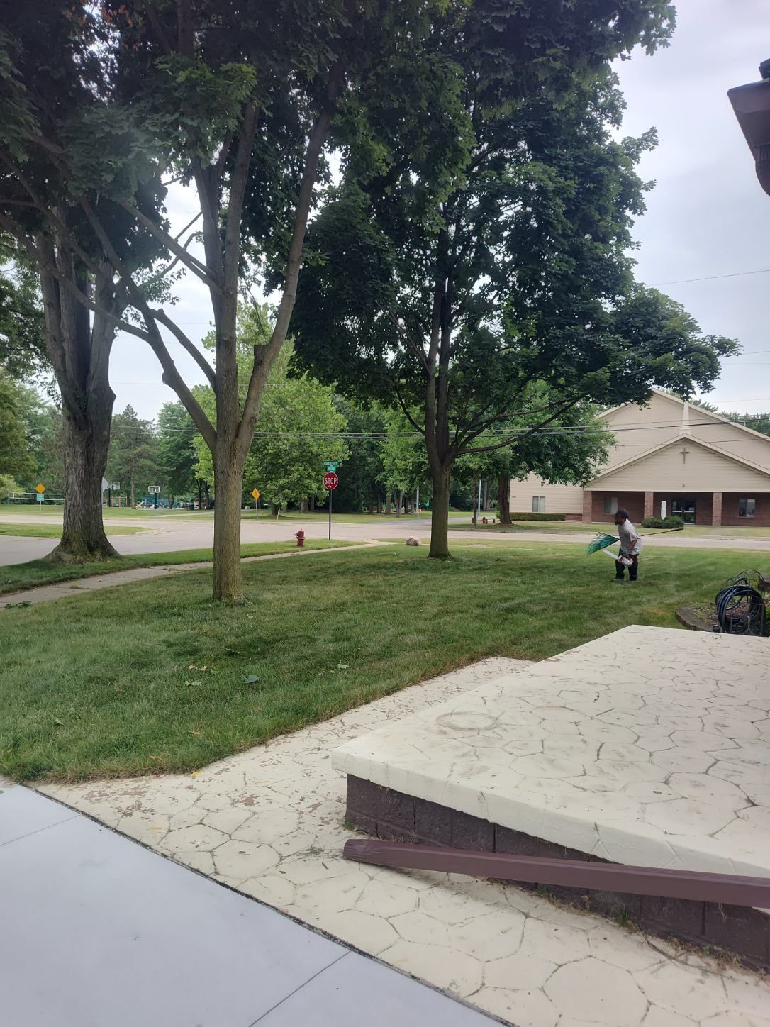 A person is sitting in the grass in front of a church