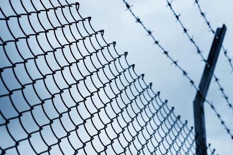 a commercial fence with barbed wire