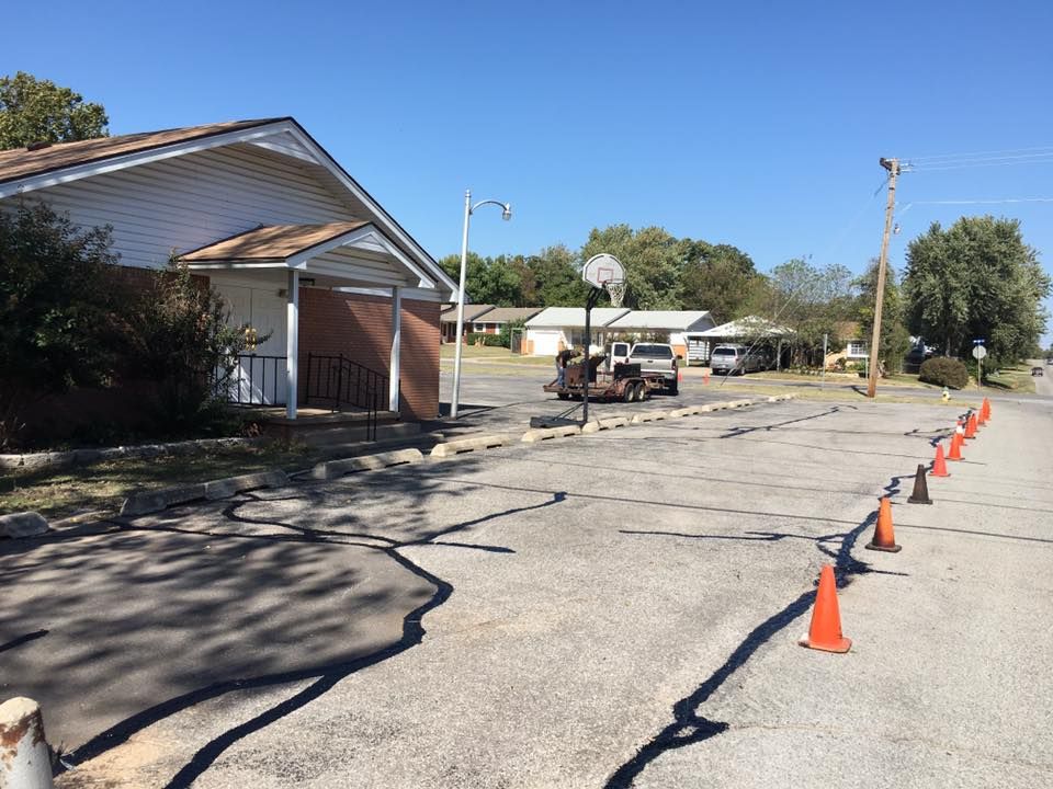 A row of orange cones are lined up on the side of a road.