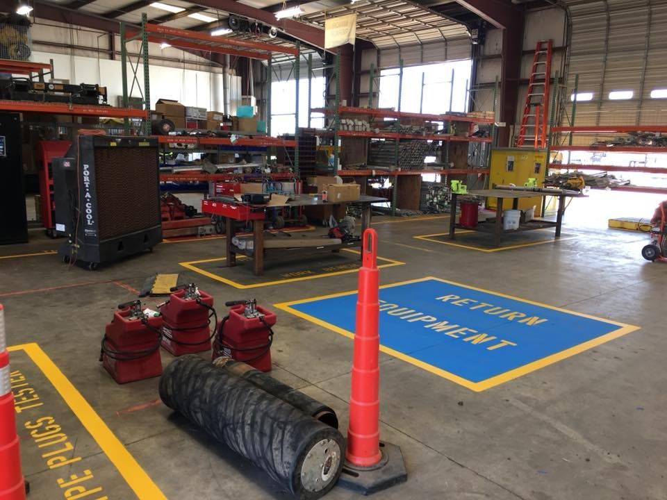 A warehouse with a blue and yellow marking that says work equipment