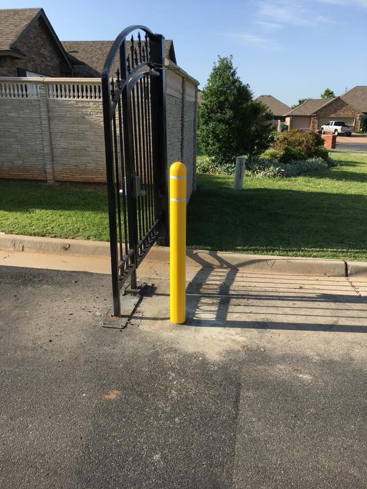 A yellow pole is in front of a gate