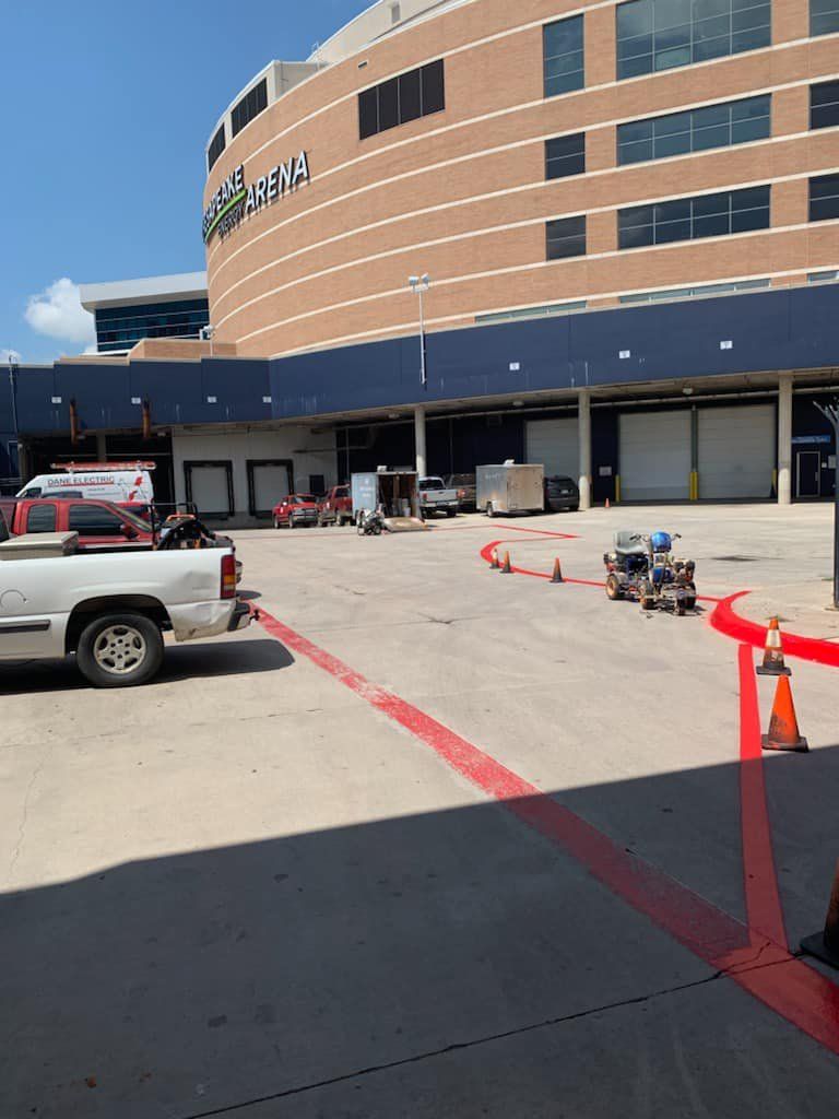 A white truck is parked in front of a large building
