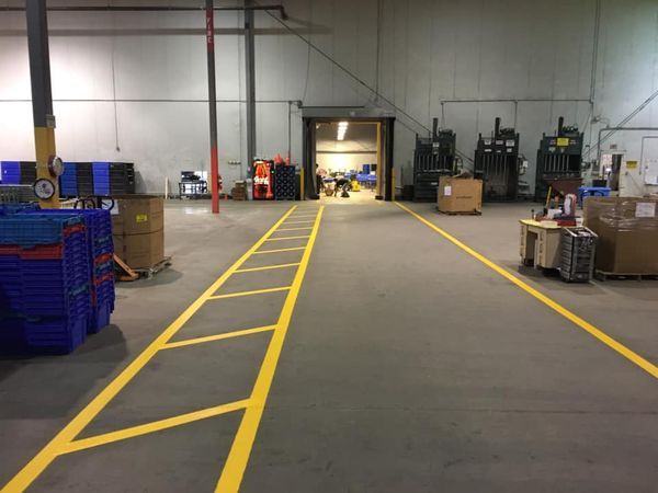 A large warehouse with yellow lines on the floor