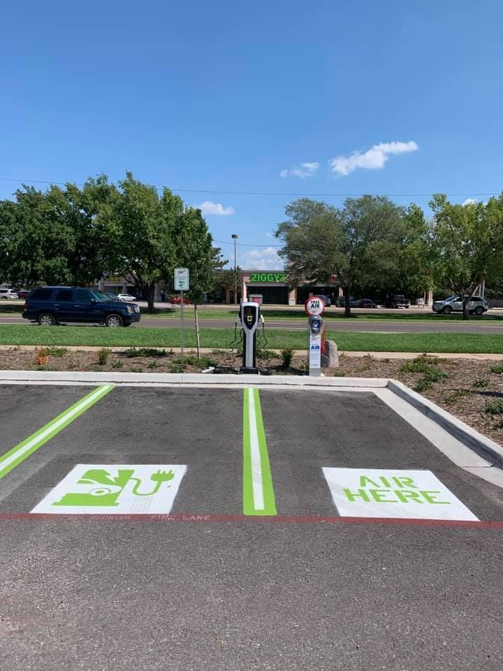 A parking lot with a charging station and a sign that says `` air here ''.