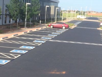 A red car is parked in a handicapped parking spot