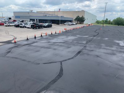 A parking lot with a lot of cars parked in front of a large building.