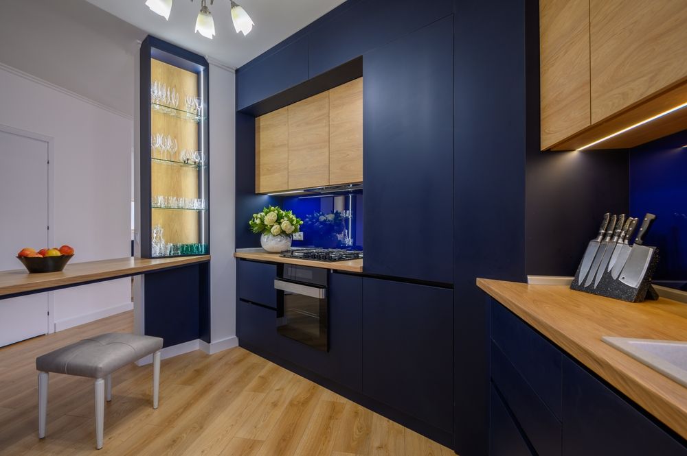 A kitchen with blue cabinets and wooden counter tops