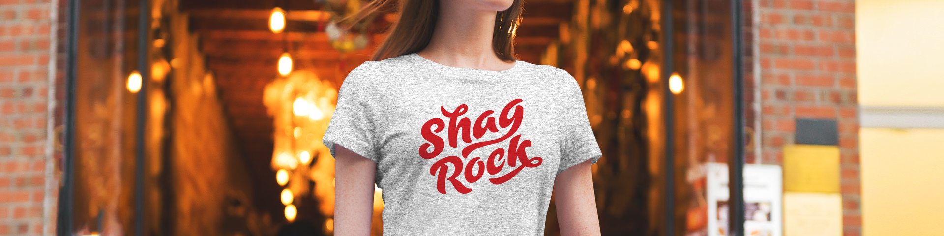 Woman wearing a Shag Rock merchandise t-shirt featuring red branding logo