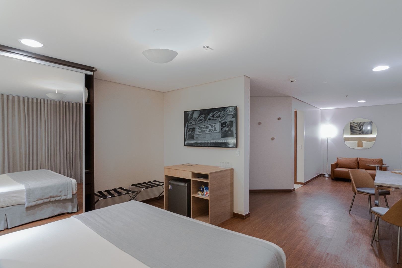 Um quarto de hotel com duas camas, um sofá, uma mesa e cadeiras.