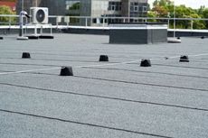A roof with a gray roof and a white air conditioner on top of it