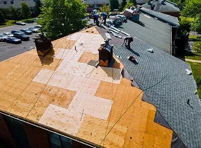 A group of people are working on the roof of a building.