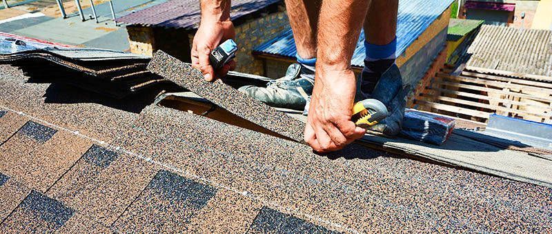 A man is installing shingles on a roof. A man is installing shingles on a roof.
