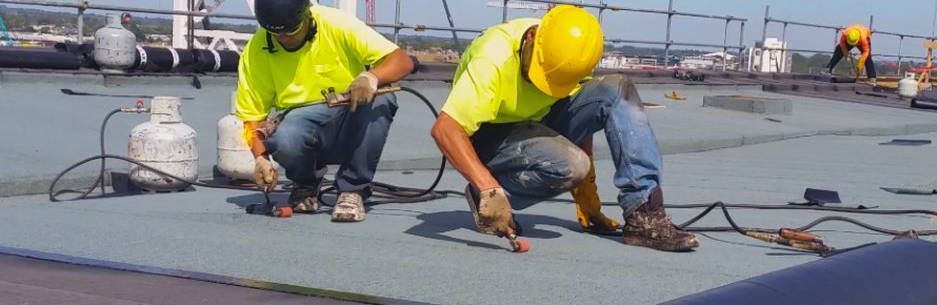 Two construction workers are working on a roof. Two construction workers are working on a roof.