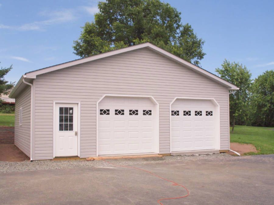 A white garage with three garage doors and a window