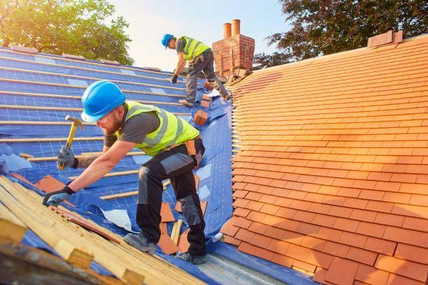 Two men are working on the roof of a house. Two men are working on the roof of a house.