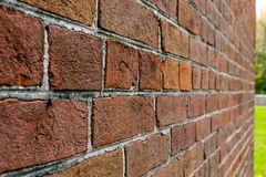 A man is laying bricks on a wall with a trowel