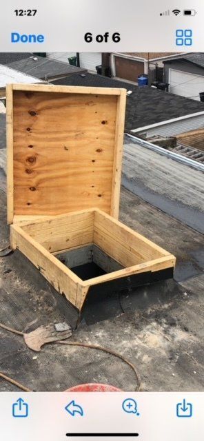 A wooden box is sitting on top of a concrete roof.