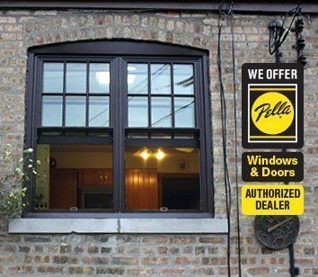 A brick building with a window and a sign that says we offer fella windows and doors