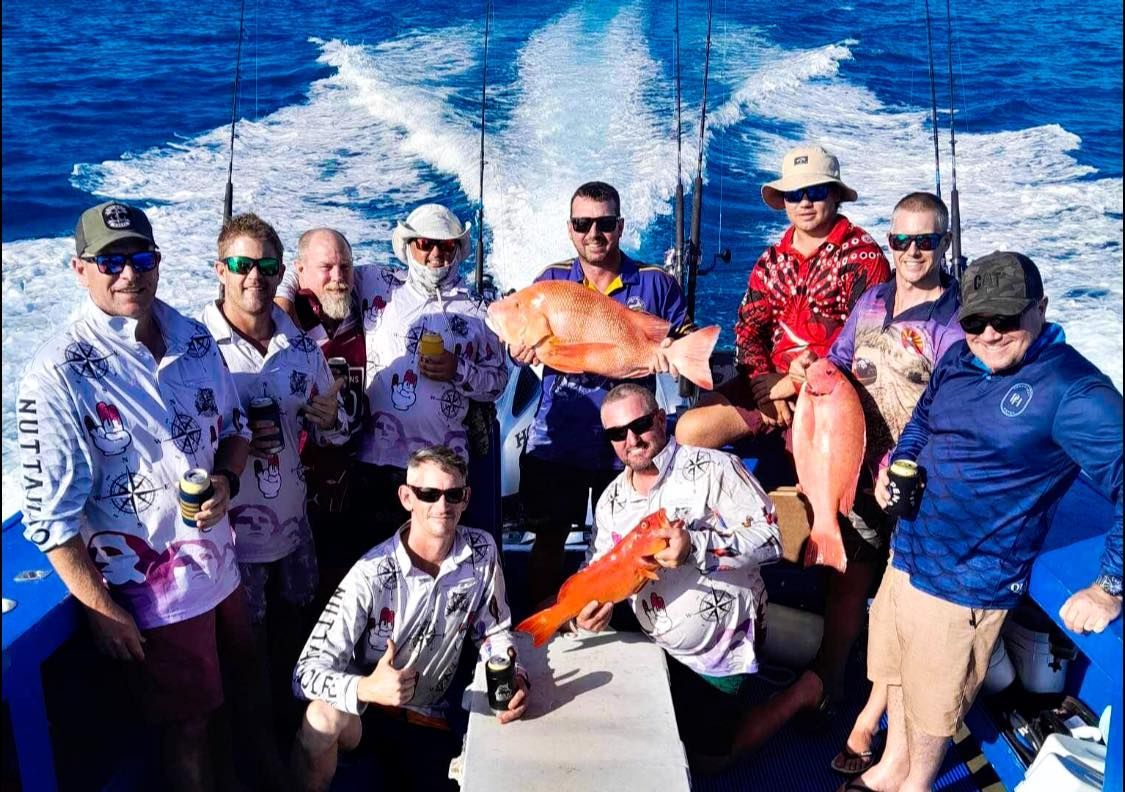 A Group of Men Are Standing on a Boat Holding Fish — Whitsunday Fishing Charters In Airlie Beach, QLD
