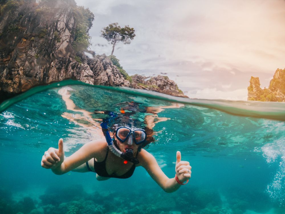 A Woman Is Giving a Thumbs up While Scuba Diving in The Ocean — Whitsunday Fishing Charters In Airlie Beach, QLD