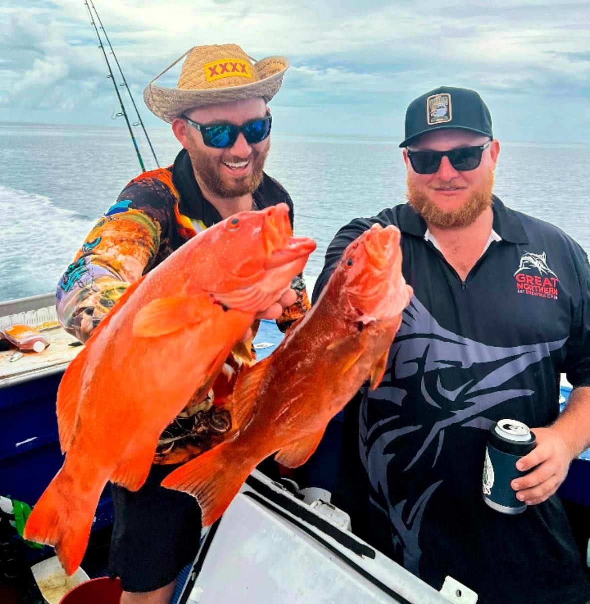 A Man in a Cowboy Hat is Holding Two Fish — Whitsunday Fishing Charters In Airlie Beach, QLD