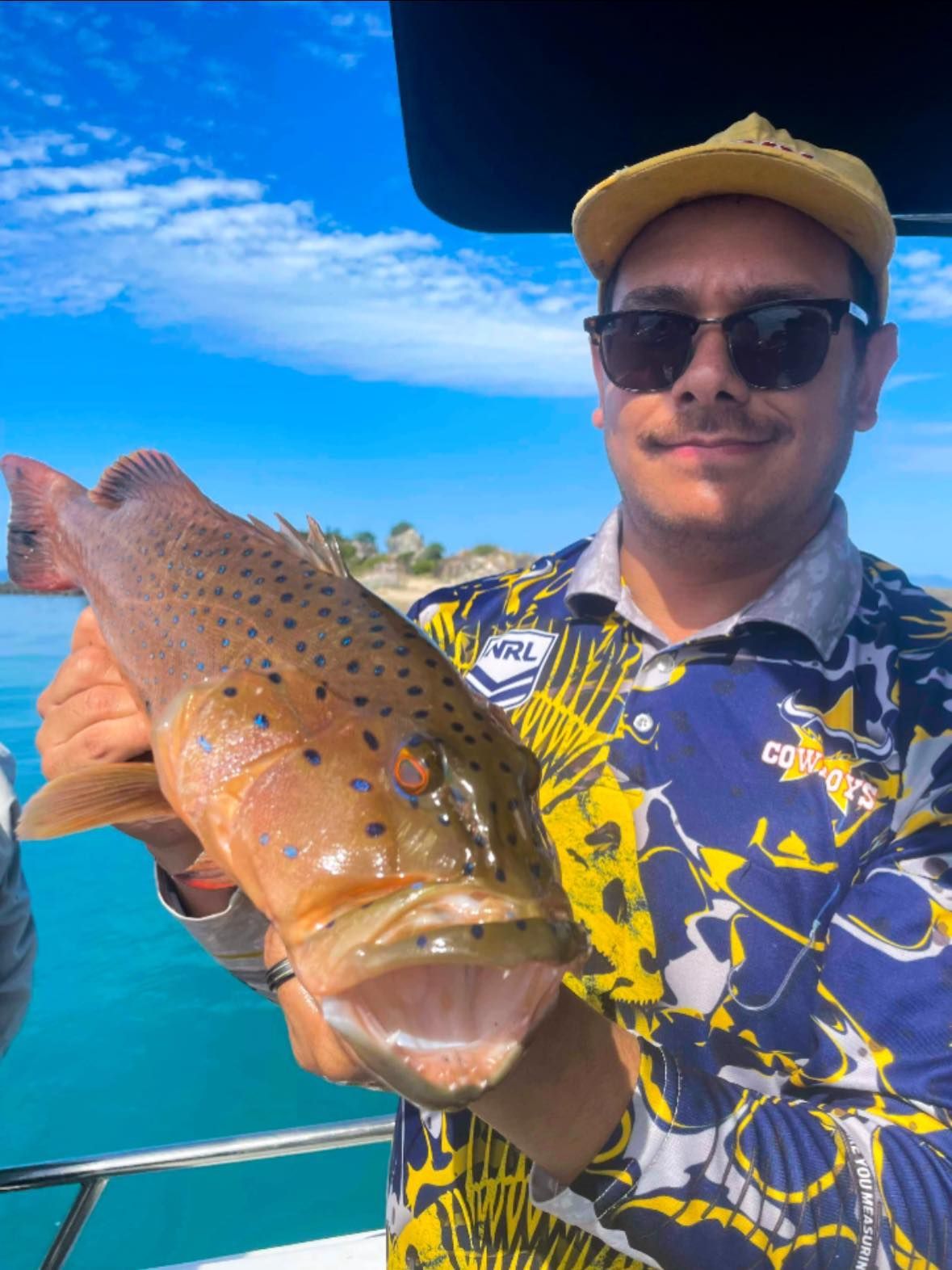 A Man is Holding a Fish in His Hands on a Boat — Whitsunday Fishing Charters In Airlie Beach, QLD