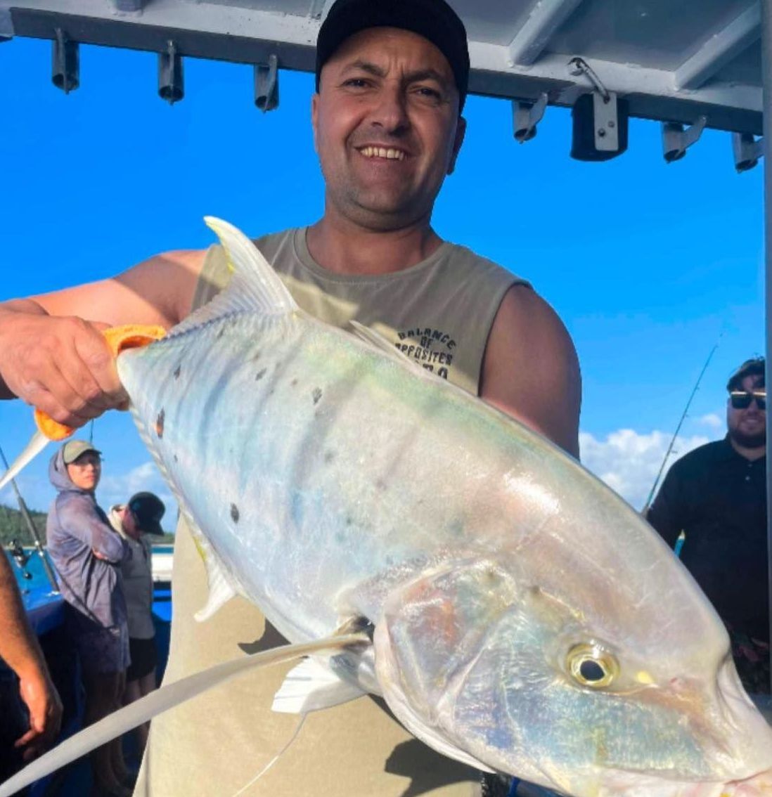 A Man is Holding a Large Fish on a Boat — Whitsunday Fishing Charters In Airlie Beach, QLD