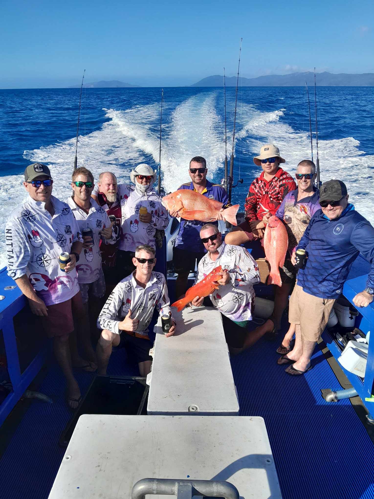 A Group of People Are Sitting on the Deck of a Boat in the Ocean — Whitsunday Fishing Charters In Airlie Beach, QLD