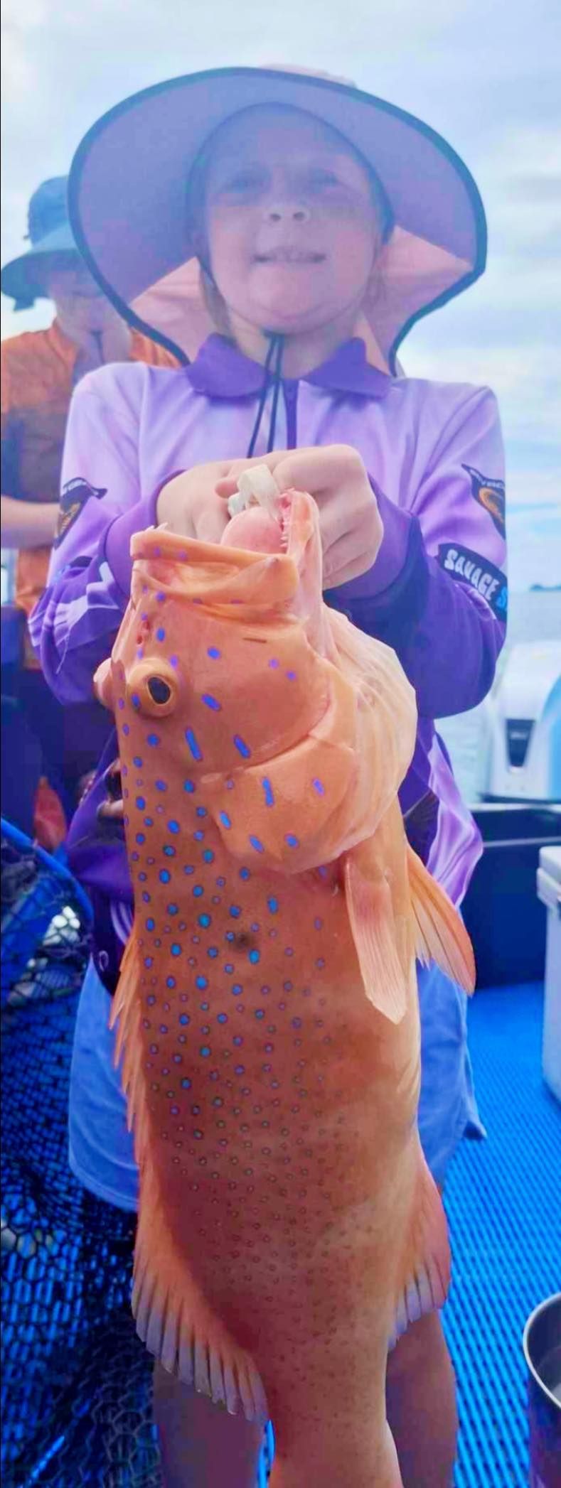 A Woman is Holding a Large Fish in Her Hands — Whitsunday Fishing Charters In Airlie Beach, QLD