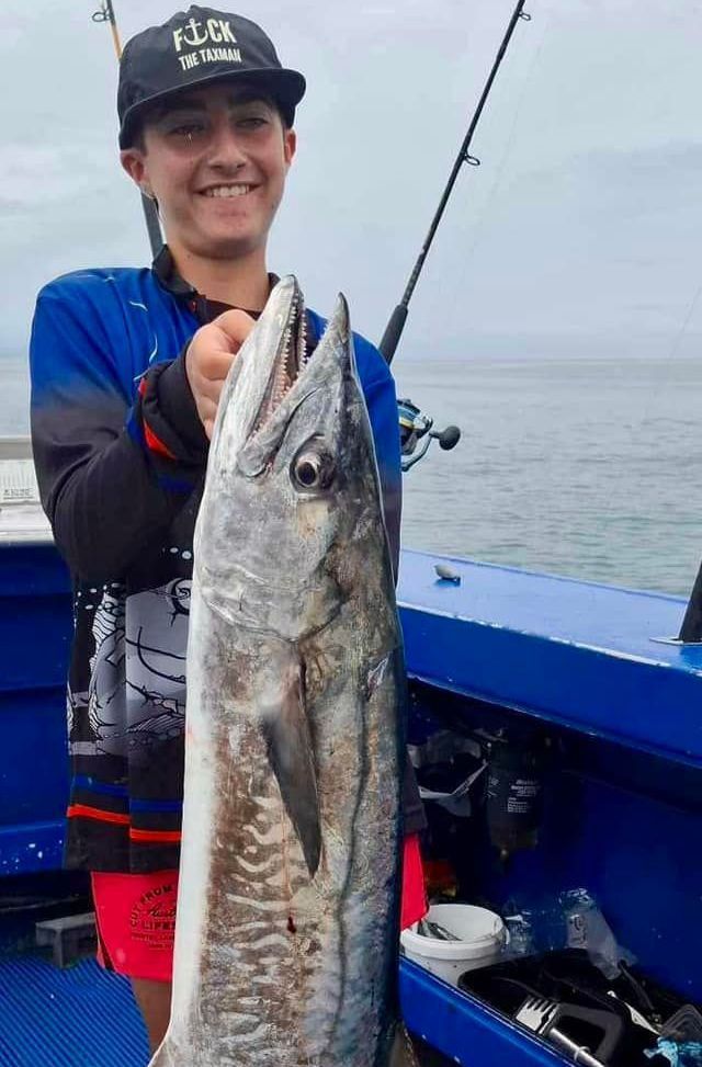 A Man is Holding a Large Fish on a Boat — Whitsunday Fishing Charters In Airlie Beach, QLD