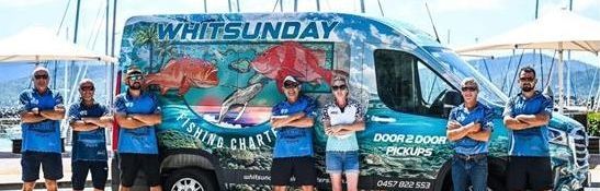 Two Men Are Holding Fish in Front of a Boat — Whitsunday Fishing Charters In Airlie Beach, QLD