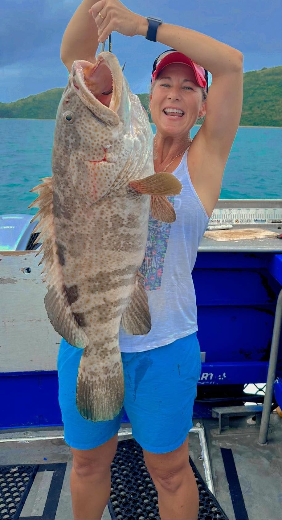 A Woman is Holding a Large Fish in Her  — Whitsunday Fishing Charters In Airlie Beach, QLD