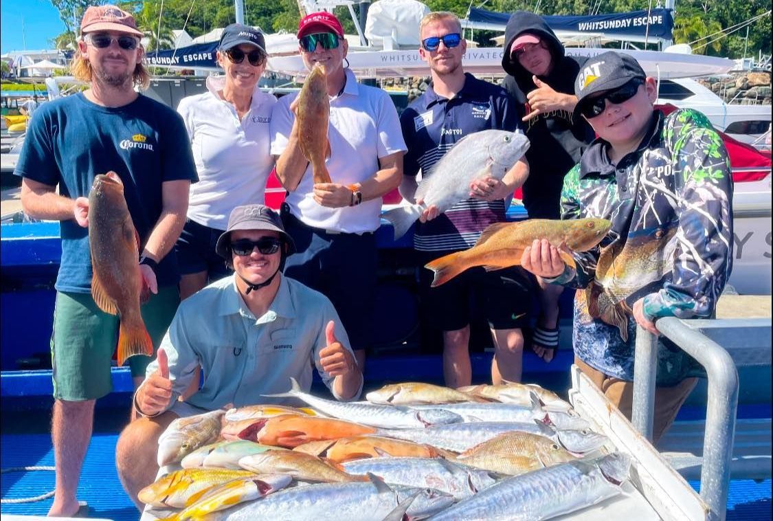 A Group of People Are Posing for a Picture With a Pile of Fish — Whitsunday Fishing Charters In Airlie Beach, QLD