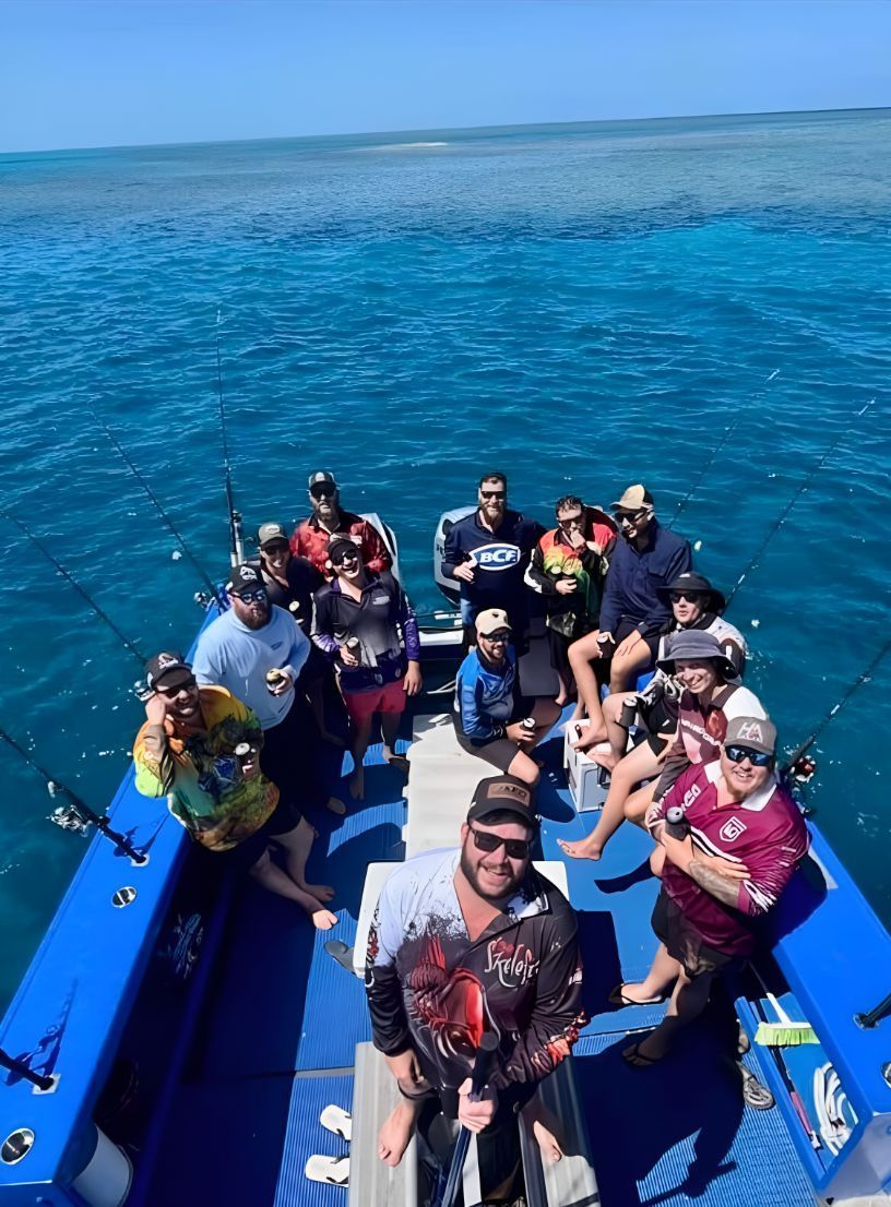 A Group of People Are Sitting on the Back of a Boat in the Ocean — Whitsunday Fishing Charters In Airlie Beach, QLD