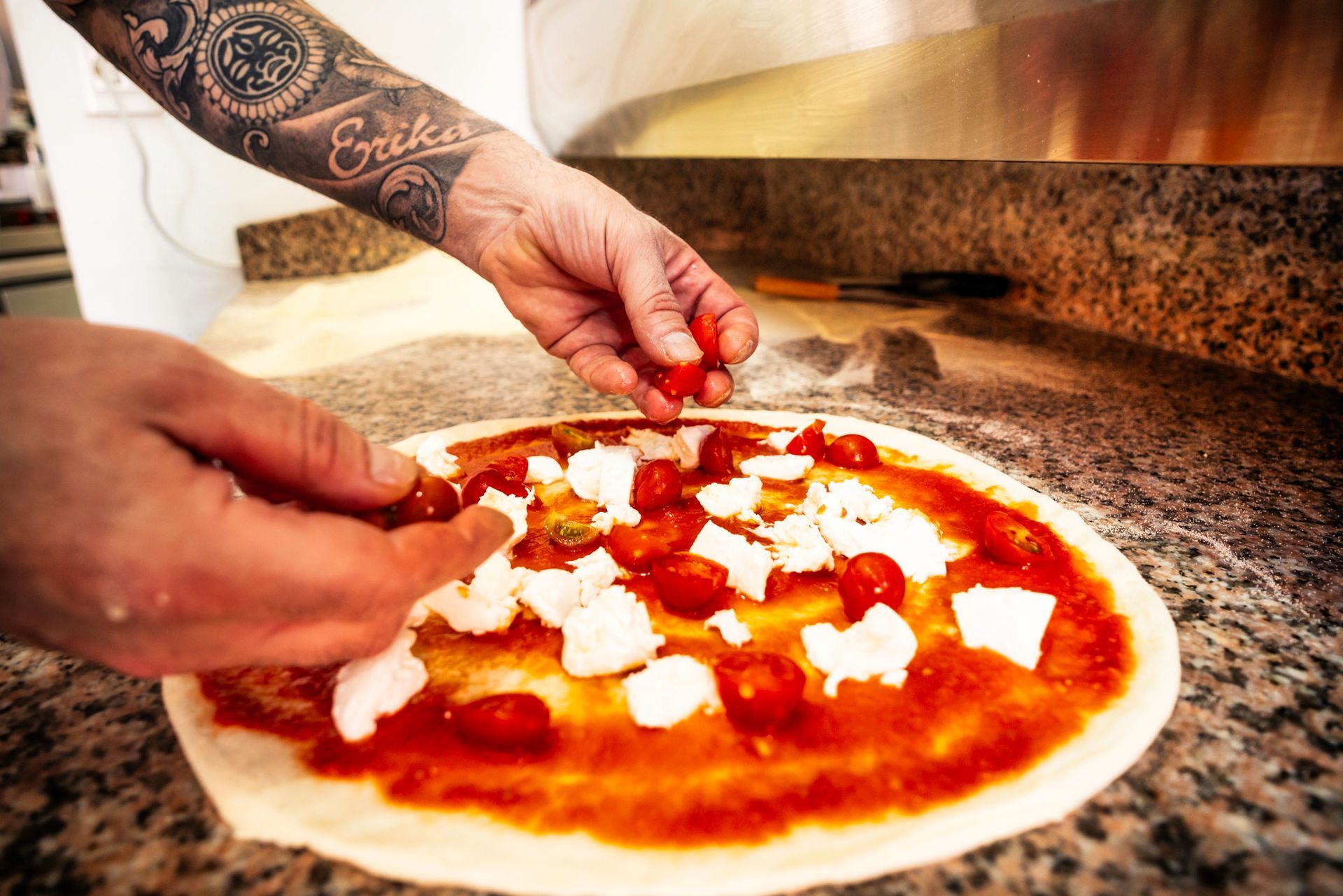 Il pizzaiolo Valentino Izzo che mostra una selezione di ingredienti di stagione