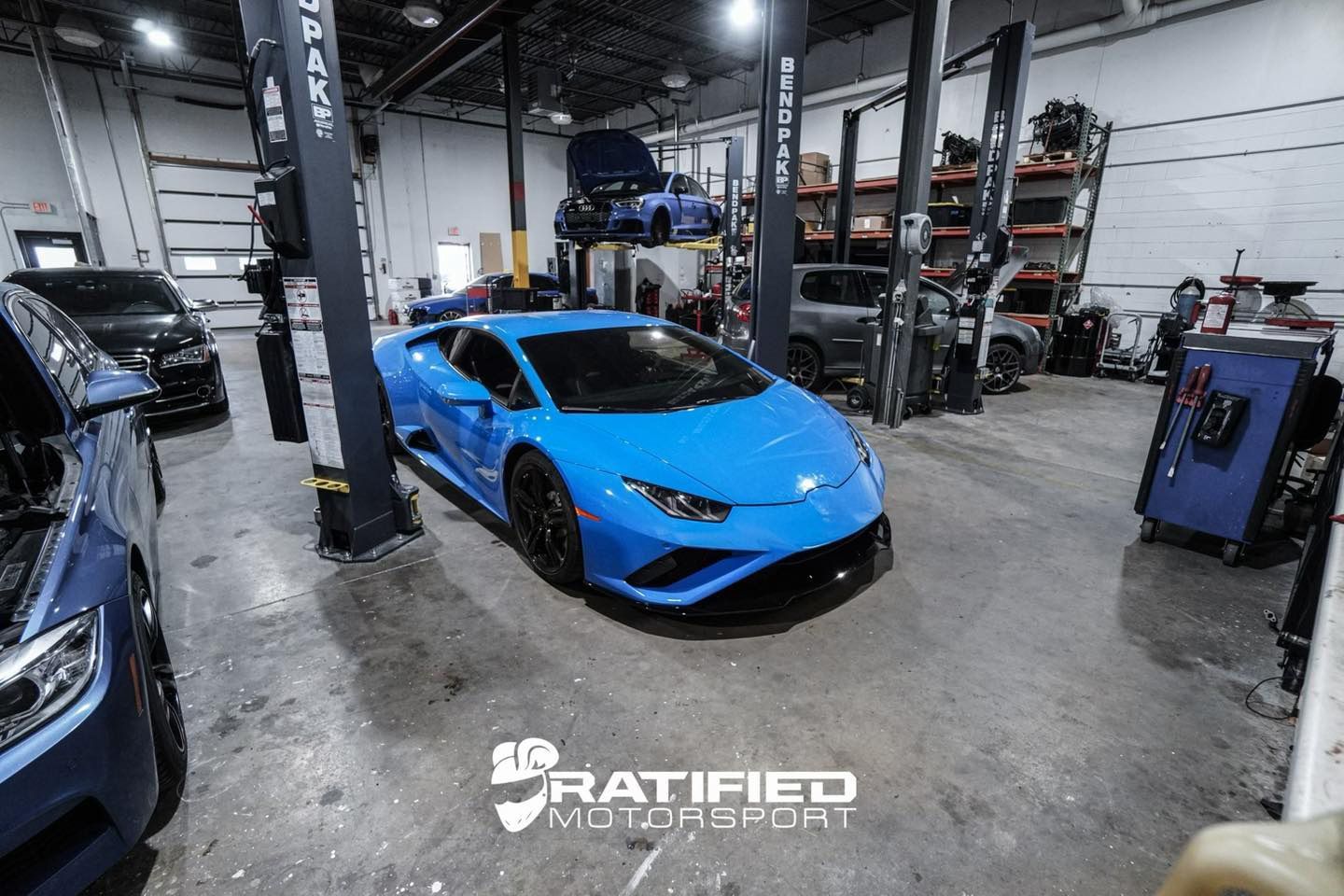Underside of a car with a custom exhaust system installed. The vehicle is raised on a lift in a garage. | Ratified Motorsport