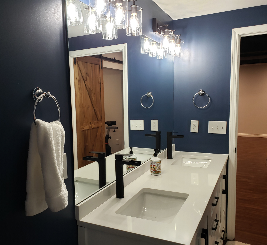 A bathroom with two sinks and a large mirror